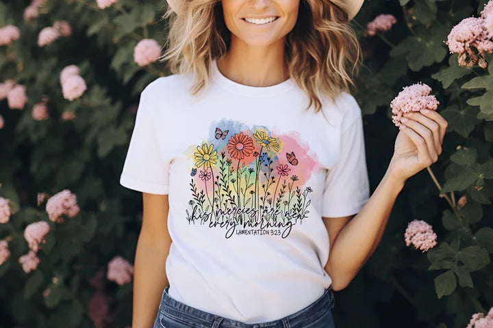 a woman wearing a white t - shirt with flowers on it