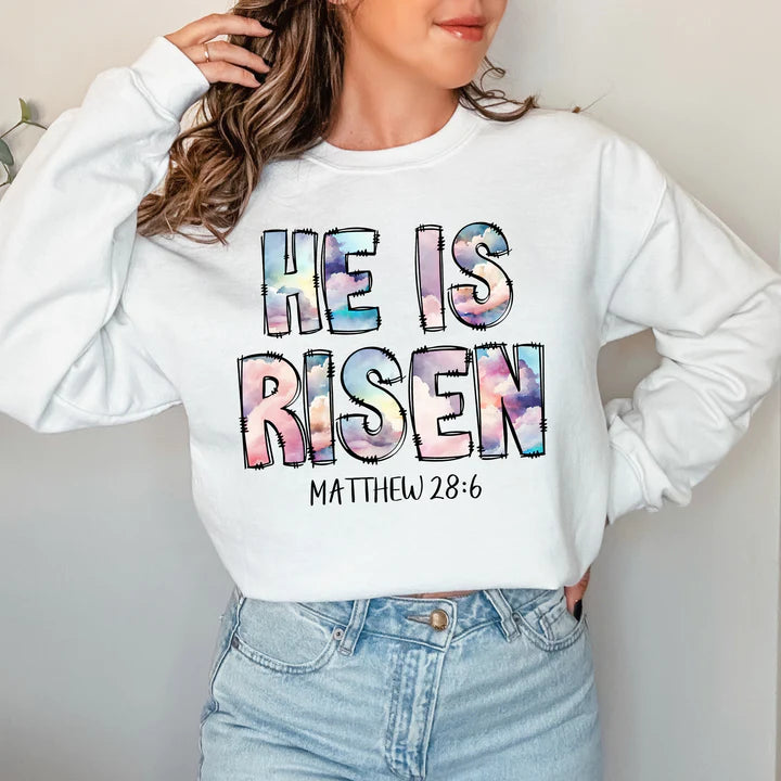 a woman wearing a sweatshirt that says he is risen