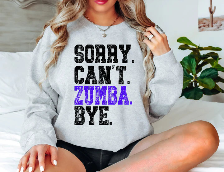 a woman sitting on a bed wearing a sweatshirt that says sorry can't zu