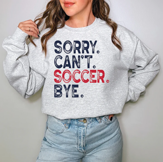 a woman wearing a sweatshirt that says sorry can't soccer bye