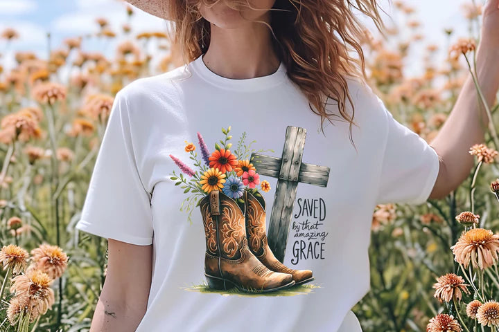 a woman standing in a field of flowers wearing a t - shirt with a cross