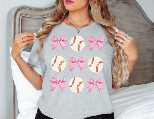 a woman wearing a gray shirt with pink bows on it