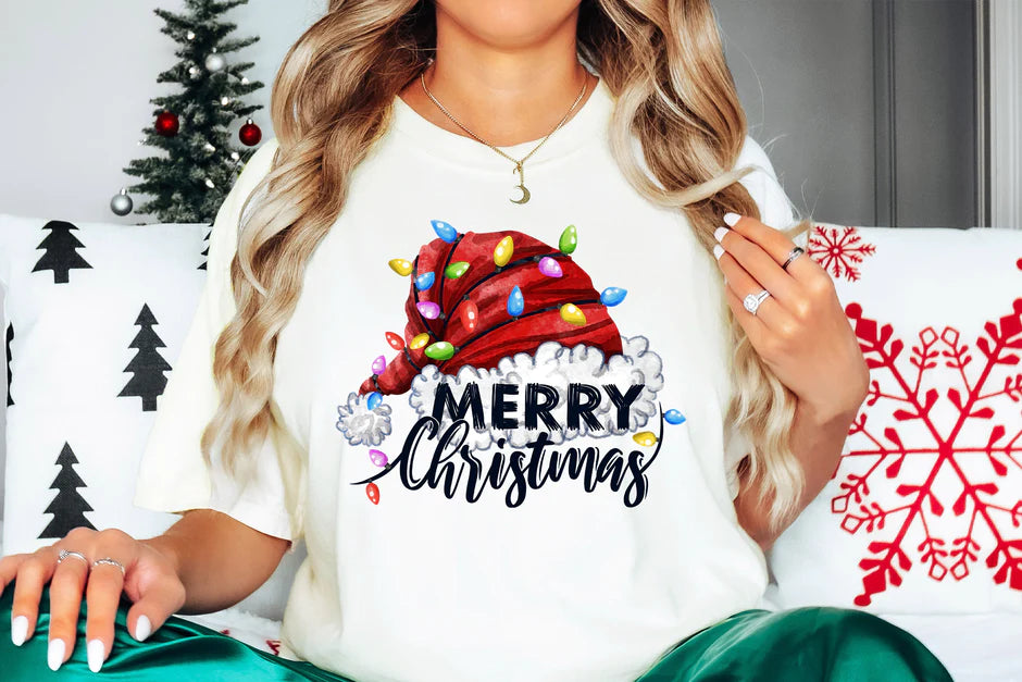 a woman sitting on a couch wearing a merry christmas shirt