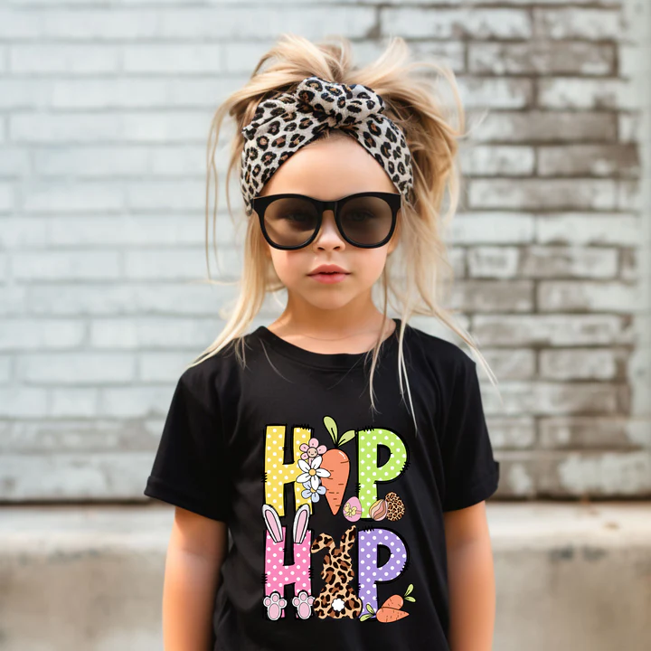 a little girl wearing a black shirt with a leopard print headband